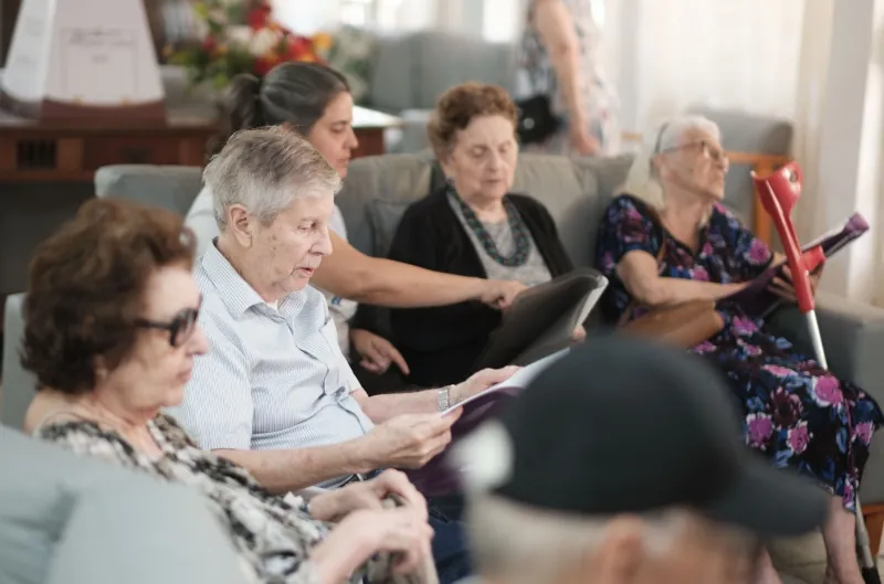 Idosos participam de atividade de leitura em grupo na sala de convivência do Residencial Menino Deus, em Porto Alegre